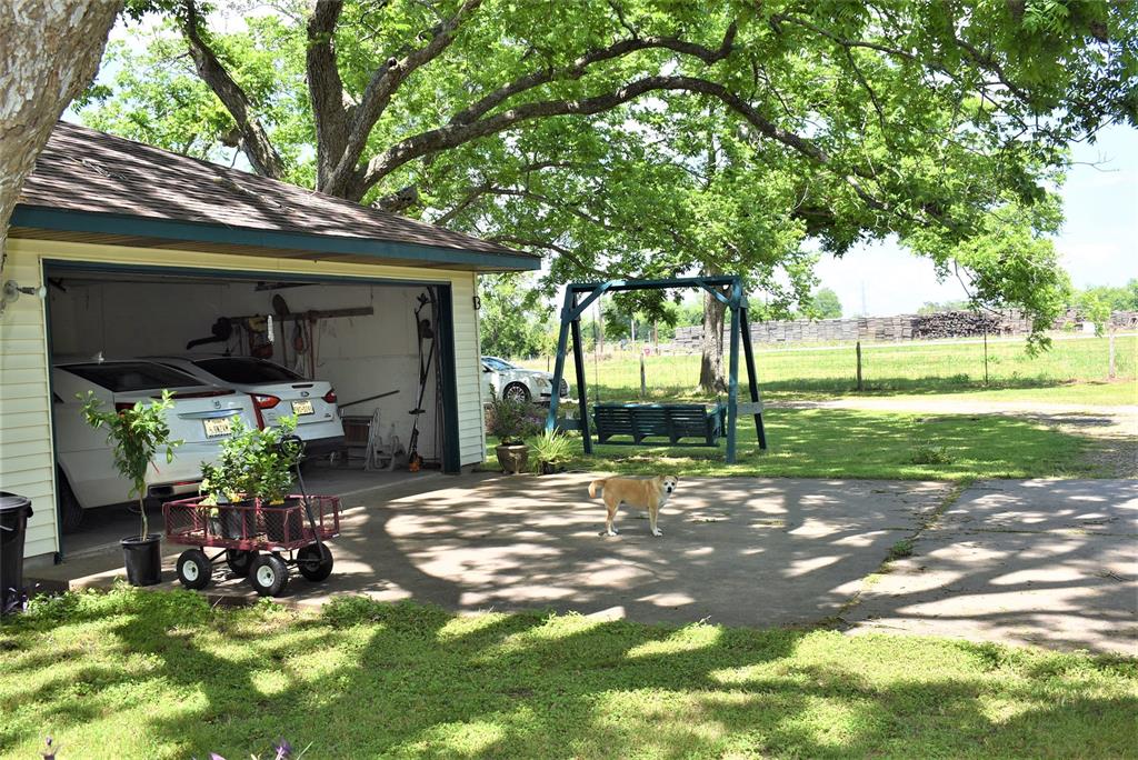 Double car garage with concrete drive on the shady side of house with nice trees