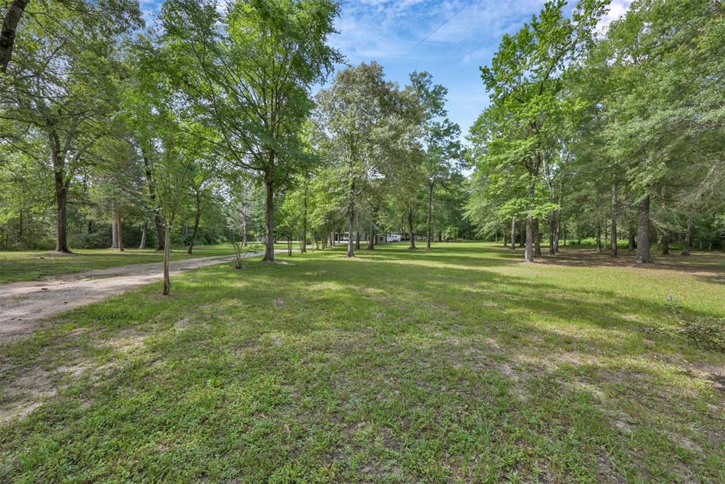This beautiful 7.6 acre tract is ready for your dream home. Located minutes away from Lake Conroe, this hidden gem is nestled in the woods for privacy and seclusion. The shop offers a nice space for you to use while building. The water and sewer are already in place on this property. This is a MUST see property.