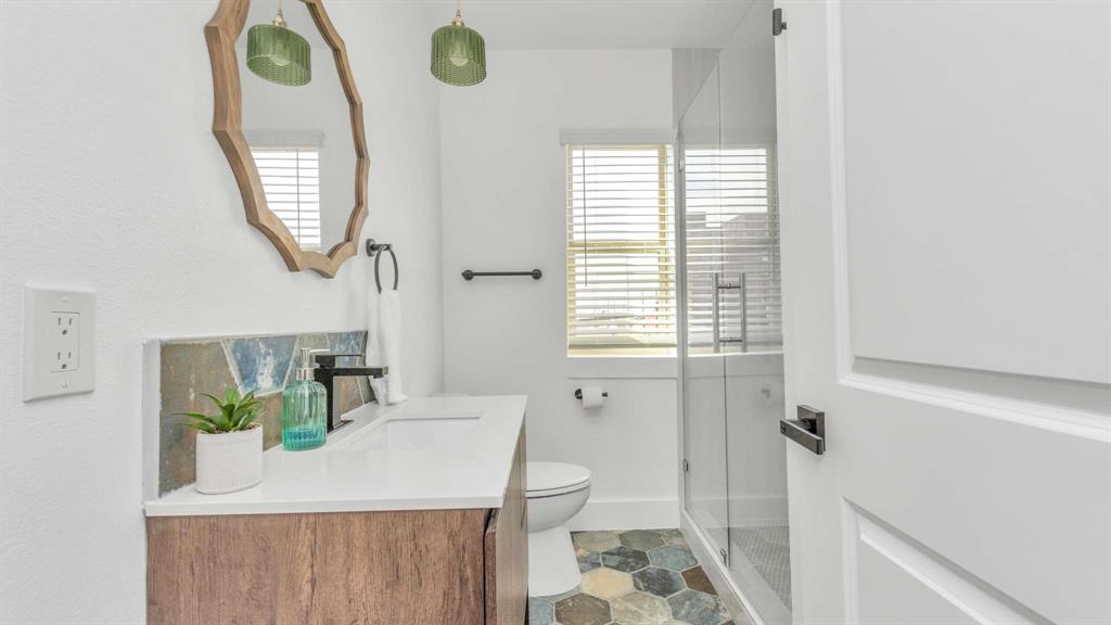 The secondary bathroom features a large walk in shower, and custom vanity.