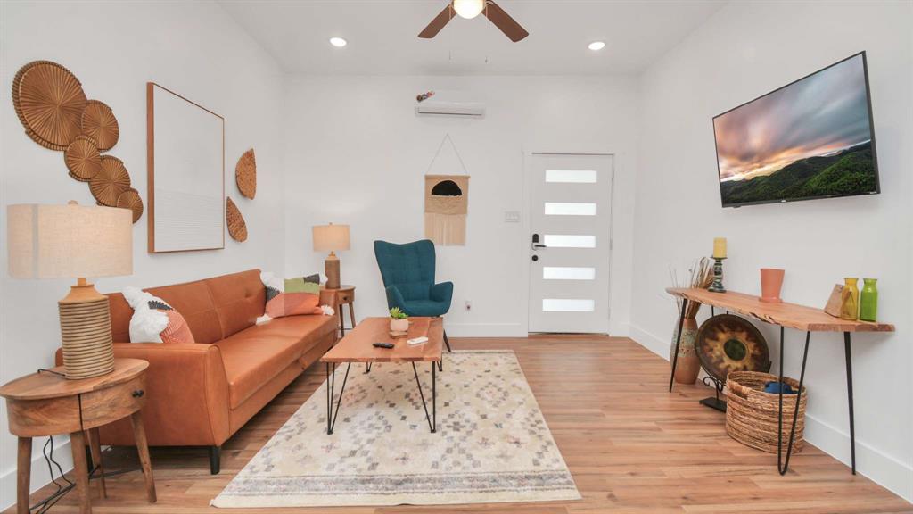 The living room features vinyl flooring with high ceilings.