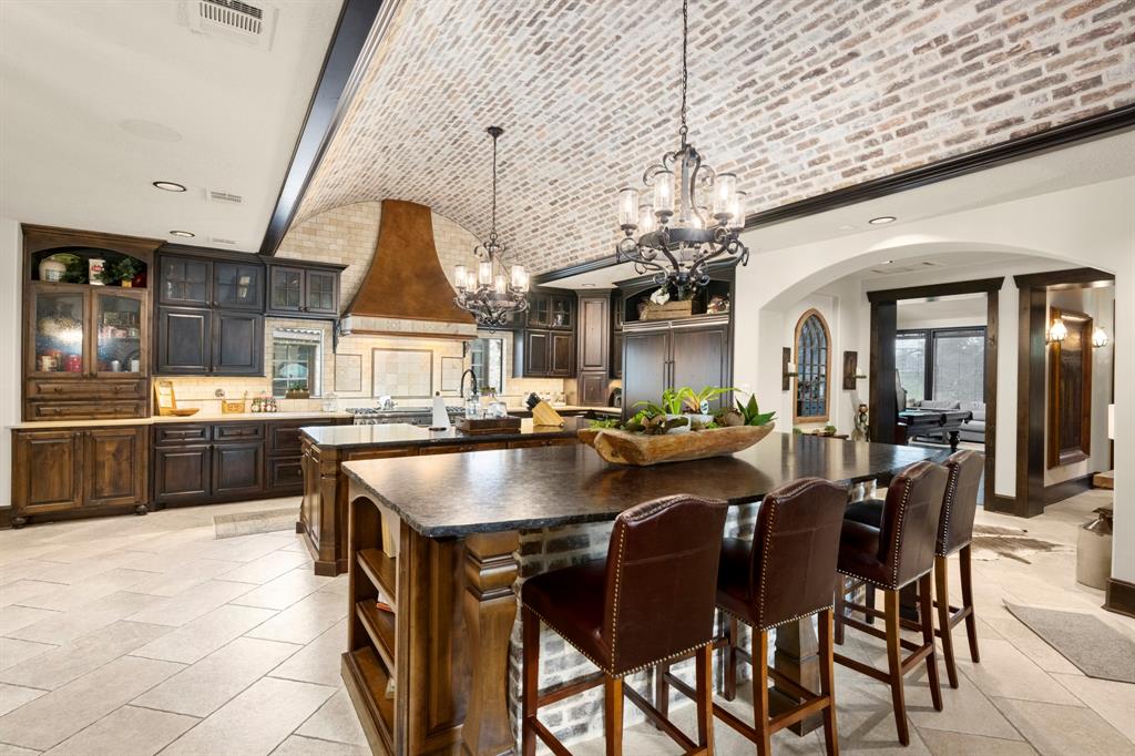 Ceiling is a barrel brick design and both islands are leather finished for a deeply ranch style look
