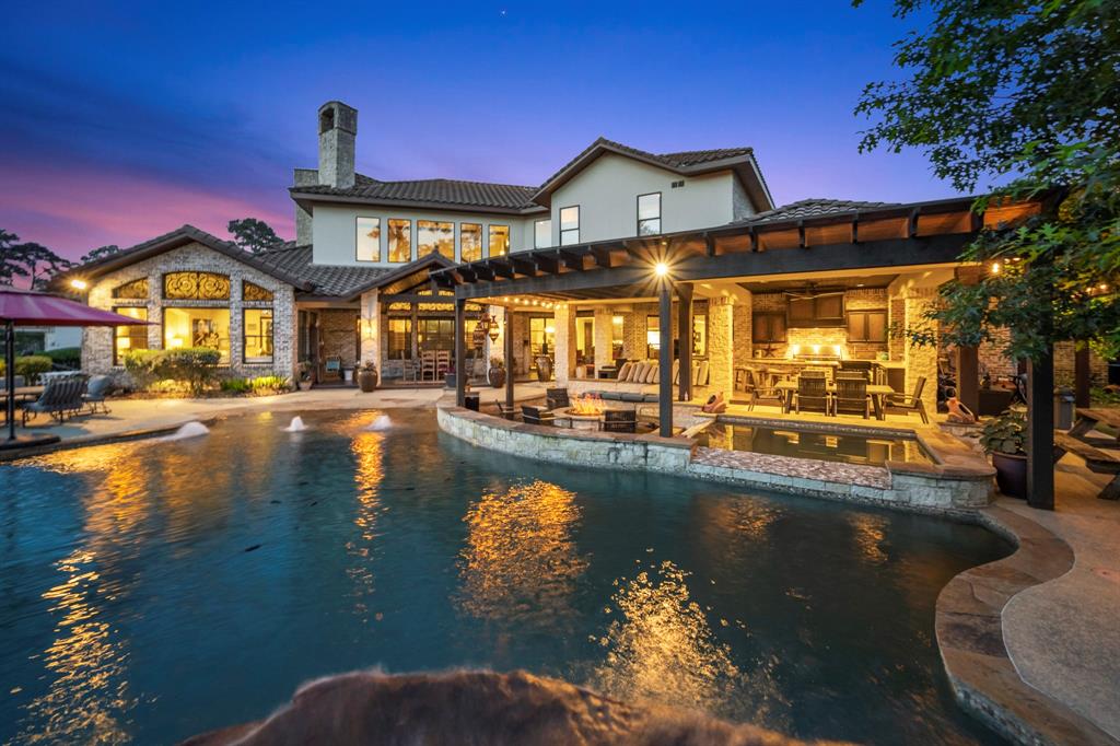 Pool area with rock slide, multiple water features, sun shelf and shoreline entrance make this back yard spectacular.