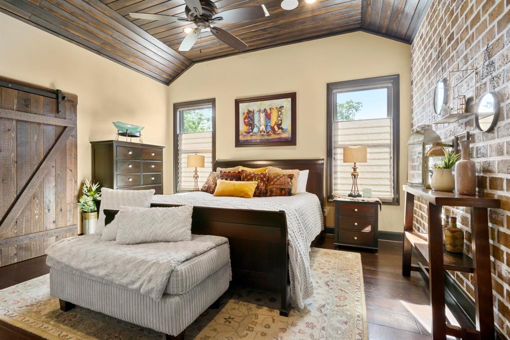 Secondary upstairs bedroom has gorgeous wood paneled ceiling details and brick wall design. Full walk-in closet with a beautiful back yard view.