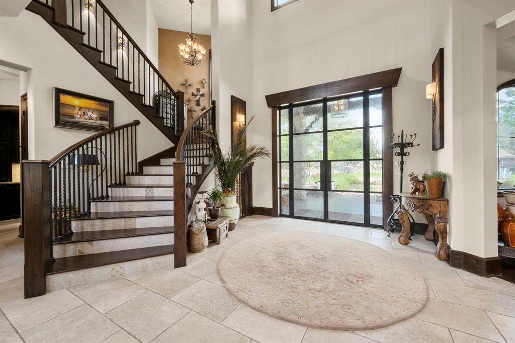 Winding stairs anchor the north side of the home with beautiful chandelier, wrought iron and wood details.