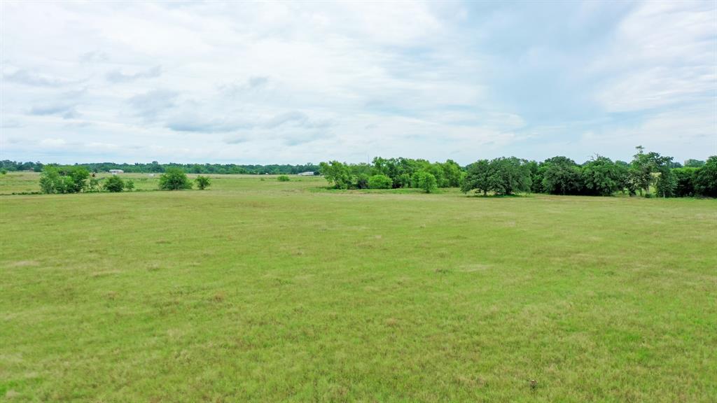Madison County, TEXAS Unrestricted Ranch Land for Sale, Featuring Beautiful Views and Paved FM Road Frontage between the Houston - Dallas Corridor.  This 50.03 Acre Tract is mostly open, presenting approximately 95% open, 5% wooded with several choice home sites, the sloped terrain affords for good drainage.  Other amenities include coastal grass, fence on 3 sides, a stock tank, another larger pond, and access to electricity in nearby (buyer to verify cost to access).  This land is used for cattle and hay production, there is an agriculture exemption in place and the seller is willing to convey all owned mineral rights with an acceptable offer.  Own your personal piece of Texas Land today.