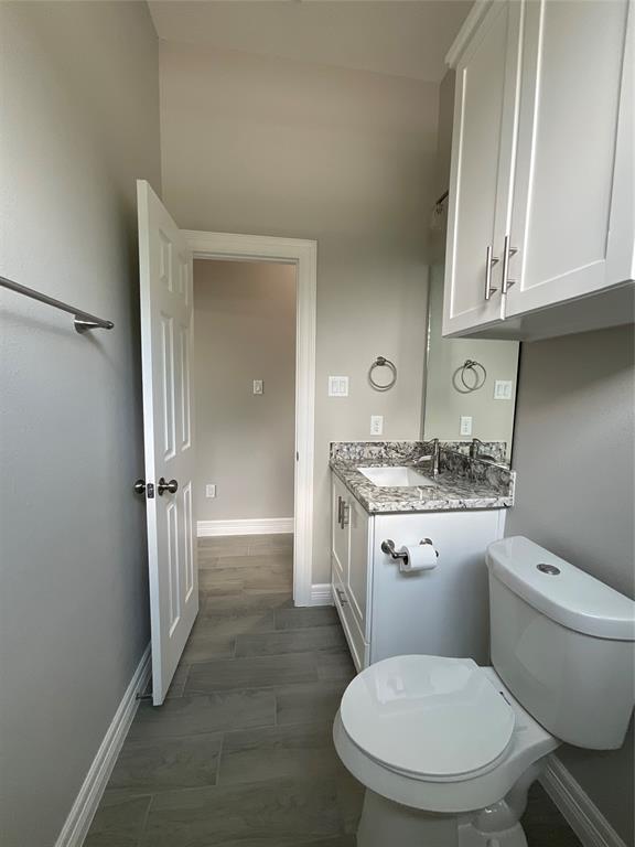View of Downstairs Bathroom showing Dual flush toilet, Granite Countertop and Waterfall Faucet.