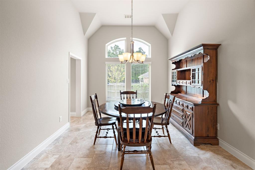 Accessible from the kitchen and entryway, find a formal dining area with generous accommodations for seating and a layout fit for large or intimate gatherings. The space features tile floors, high ceilings, and large windows offering an abundance of natural light.