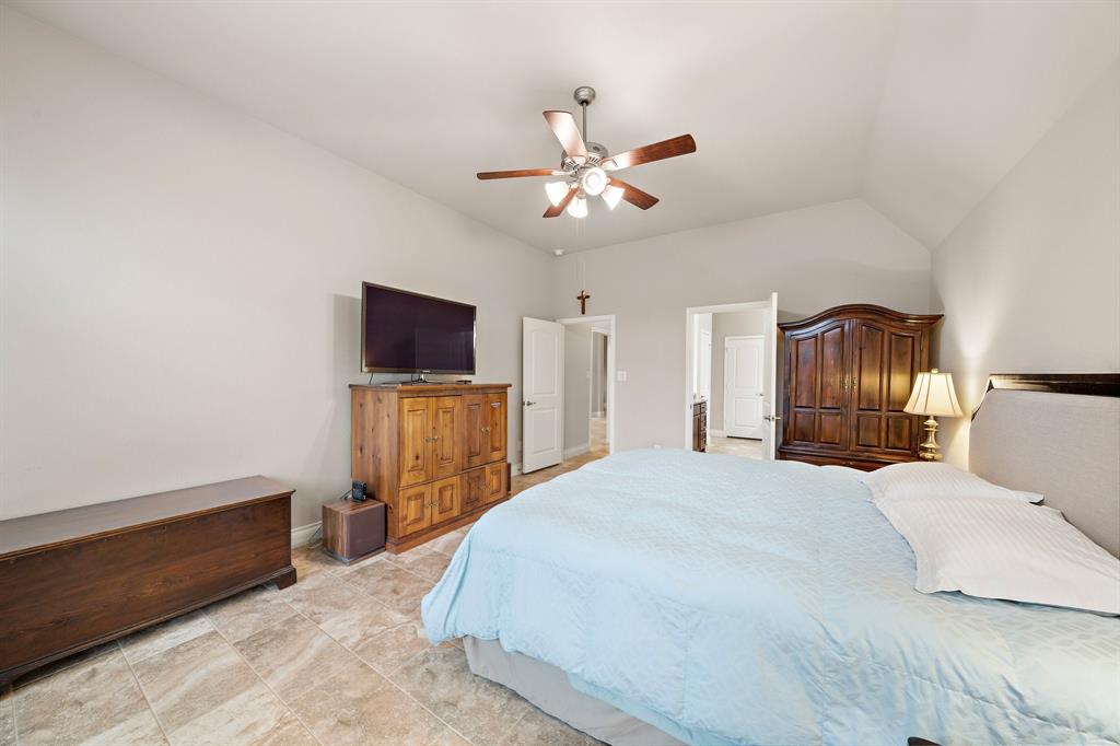 Built for convenience, the primary suite features custom tile flooring, tall vaulted ceilings, and a spacious ensuite bathroom.