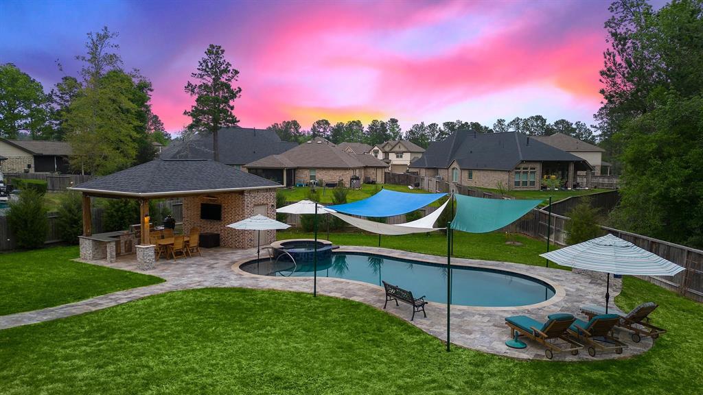 Catch beautiful sunsets in the fully-fenced backyard, offering multiple lounging areas by the pool with easy access to the cabana, summer kitchen, and half bath.
