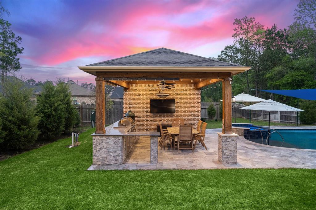 The covered cabana in the backyard flaunts an outdoor kitchen, wooden pillars, a seating area, extra storage, a half bath, and a brick accent wall fit for an entertainment center—all conveniently located right beside the pool. This area is the perfect spot for hosting outdoor gatherings and enjoying meals in the fresh air.