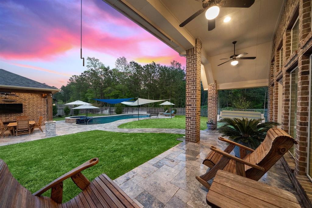 Conveniently accessible from the living and breakfast areas, the fully-fenced backyard features a pool, a brick cabana, and a covered patio complete with brick columns, ceiling fans, a retractable screen, extra seating, and a hanging chair.