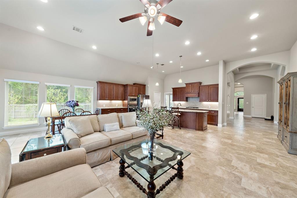 Designed for entertainment, the living area showcases 13-ft ceilings, tile floors, tall windows, and a great flow to the kitchen and breakfast areas—all offering plenty of space for seating. Find an arched entryway that leads to the dedicated study, utility room, formal dining, and bedrooms.