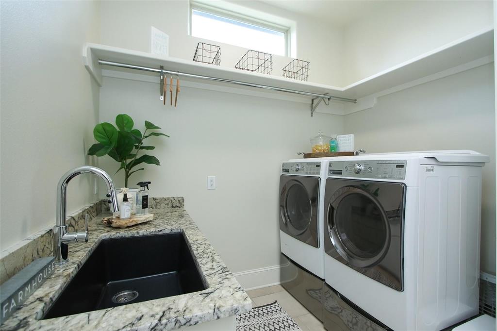 Laundry room features farm sink and above shelving, and under cabinet and drawer storage space