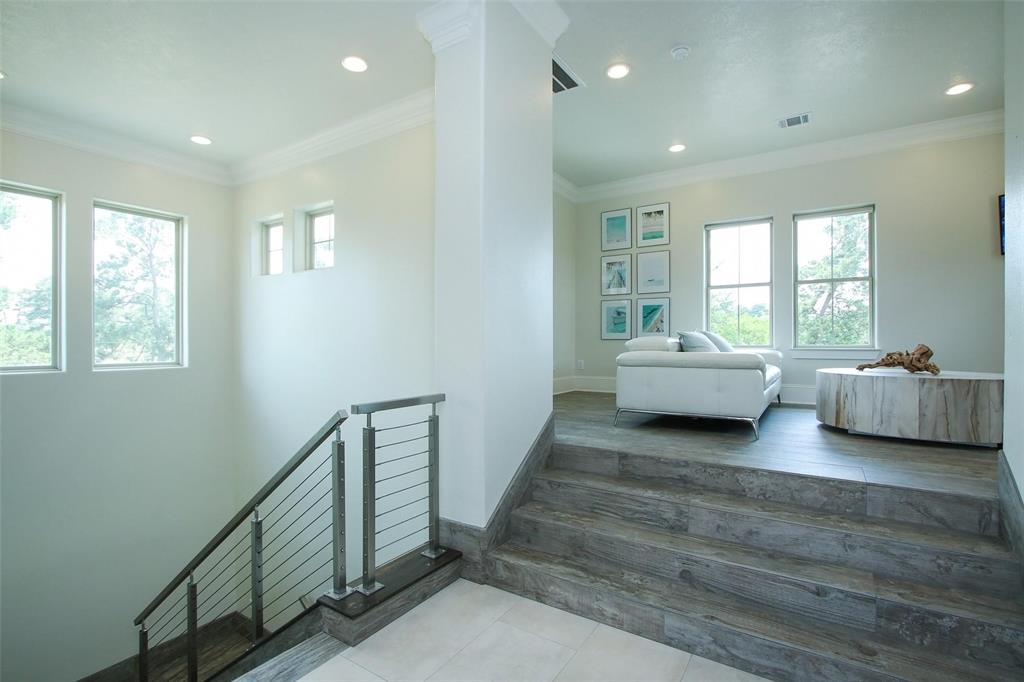 Staircase leading to study/gameroom/or workout space just off the primary bedroom. Notice the beautiful view from all of the windows. * Elevator capability; door just to the Right. (Currently used as a storage closet)
