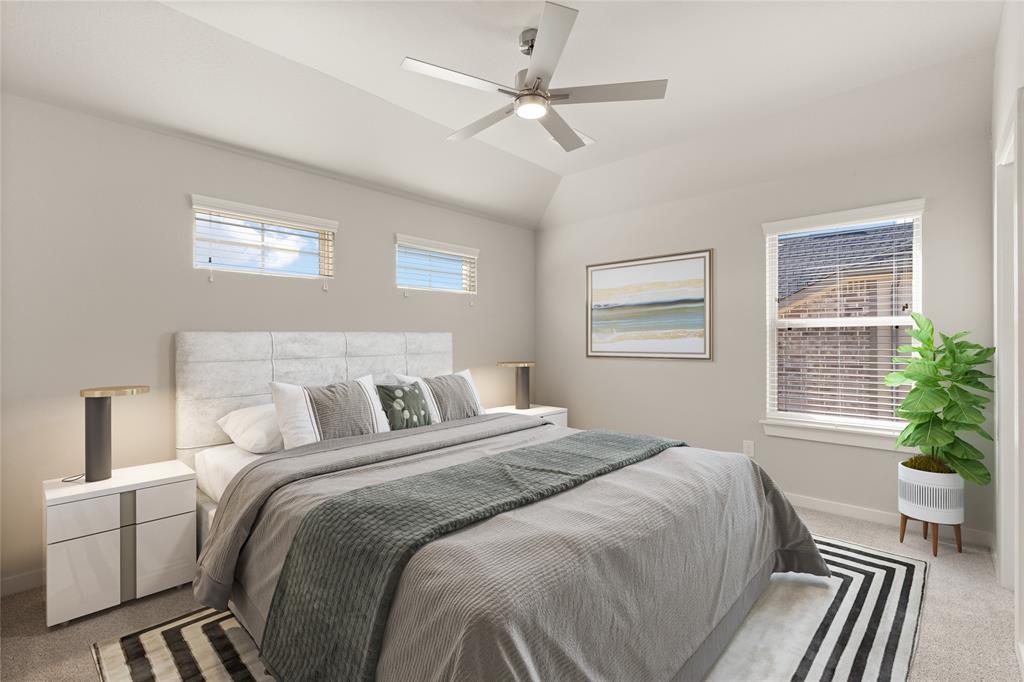 Secondary bedroom features plush carpet, custom paint, ceiling fan with lighting and large windows with privacy blinds.