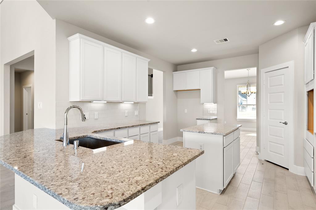This kitchen is by far any chef’s dream! This spacious kitchen features high ceilings, white stained wood cabinets, granite countertops, SS appliances, modern tile backsplash, recessed lighting, extended counter space, granite kitchen island with space for breakfast bar, and a walk-in pantry all overlooking your huge family room.