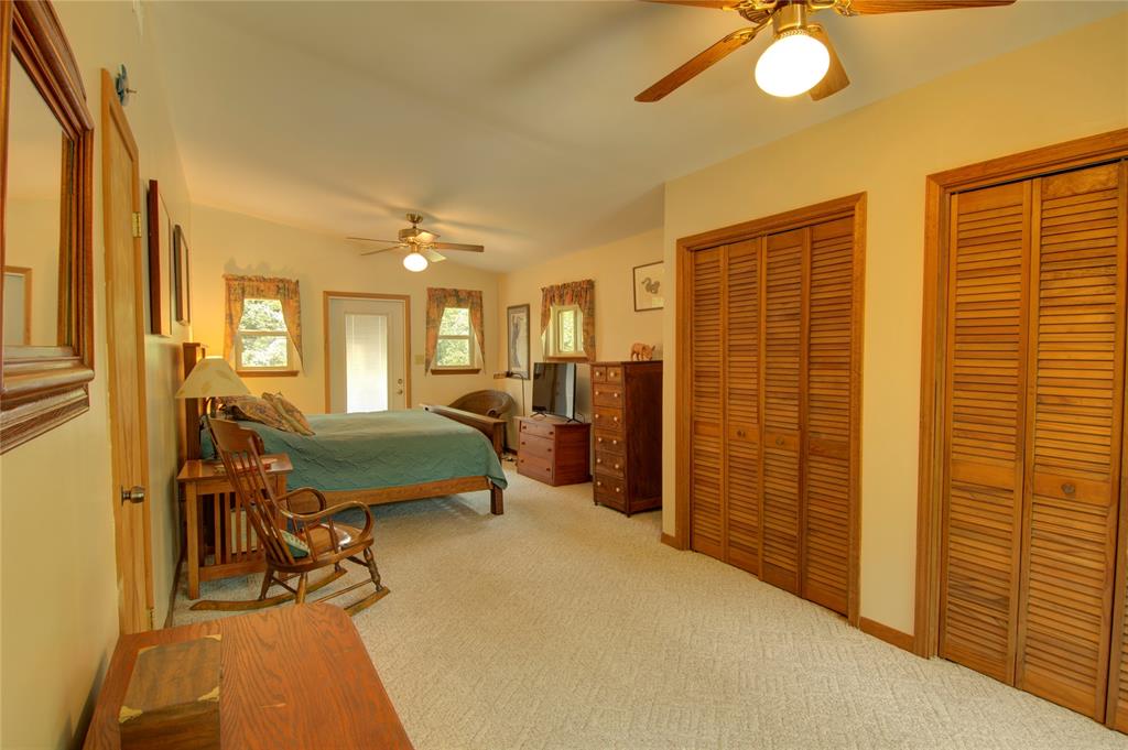 This large primary bedroom offers space for a separate sitting area, and three closets.