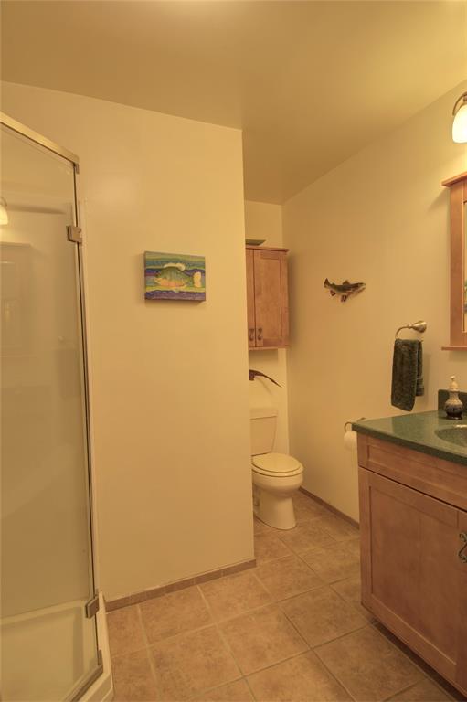 The primary bathroom is L-shaped and has tile flooring.