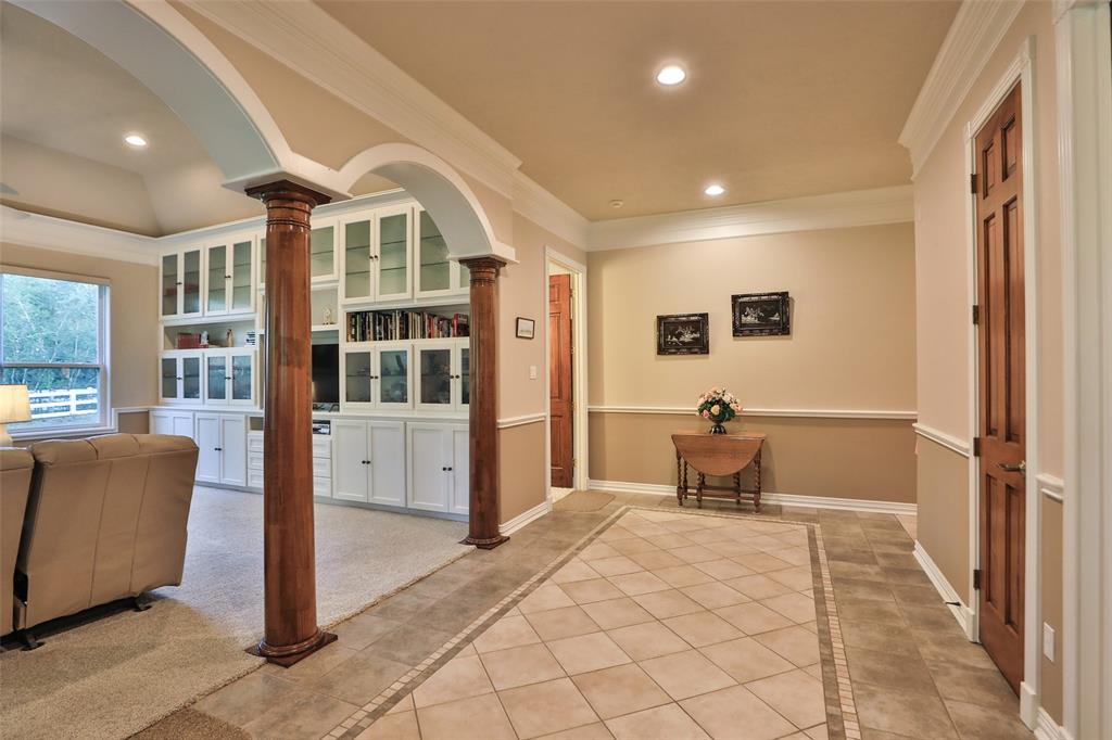 Welcome to this extra wide foyer!  Notice the double crown molding, arches, wooden columns, and chair railing. The original owner, this seller took pride un the building process.