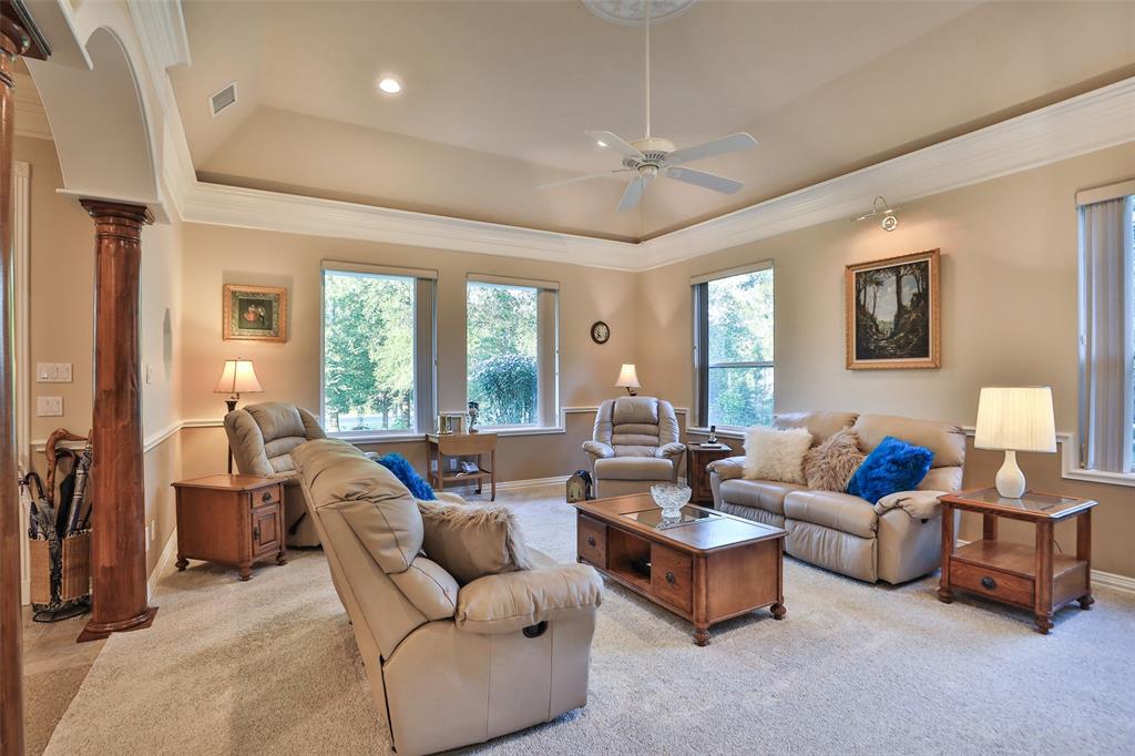 This large living room features crown molding, coffered ceiling with central rose, and plenty of windows to let the natural light in!