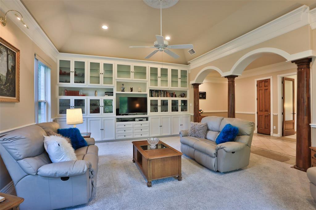 Another view of this spectacular living room with wall to wall built in entertainment center with glass fronted display cabinets and plenty of storage!