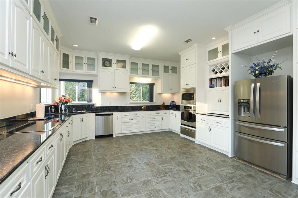 Kitchen features microwave/convection combo, convection oven, and warming drawer. Appliance garage, pull out drawers in cabinets, pull out spice storage, and cushion floor that looks like slate tile complete this huge kitchen.