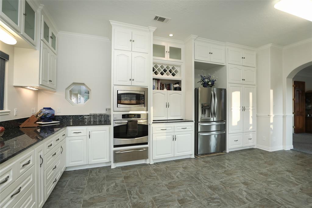 Another view of this magnificent kitchen. Kitchen has a wine rack for your wine bottle storage, shelf for your cookbooks and the hidden appliance garage.