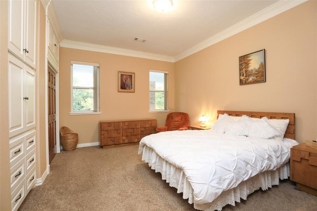 Bedroom features crown molding, wall units, nice closet and generous extra storage cabinets.