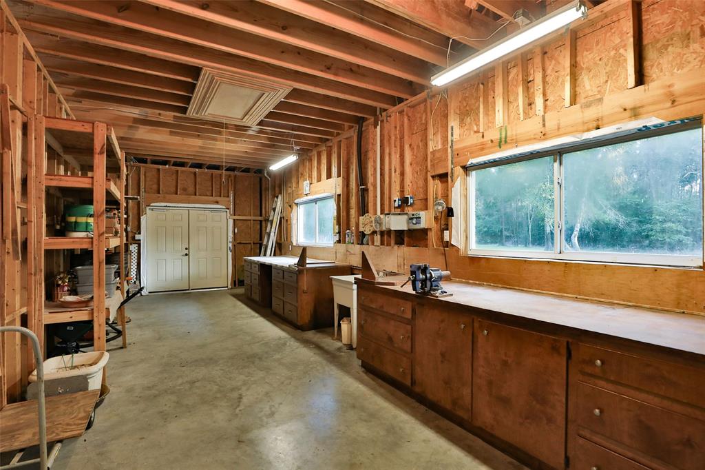 800 sq ft workshop is integral behind the garage with 2 separate workbenches each with purpose-designed cabinets and drawers, work sink, plenty of power points, lighting, and shelf storage. Large windows for natural light and also plenty of electric light.