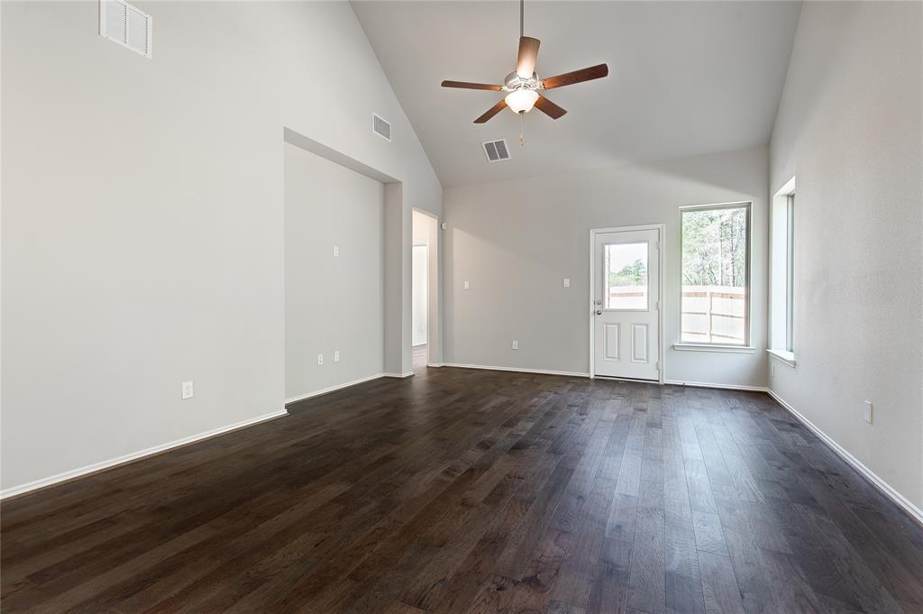 Family room has high ceilings, lots of light and a nook for home entertainment center, bookshelves, or even desk.