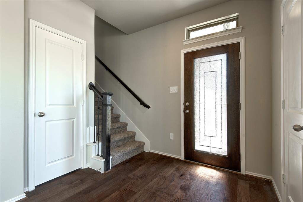 Exquisite front door, coat closet on the left, half bath on the right. Elegant foyer. Hardwood floors are extra nice throughout the home.