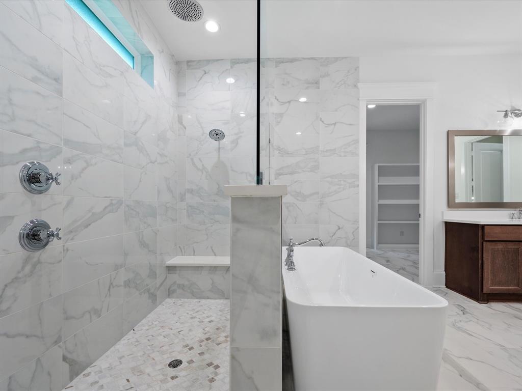 Walk-in shower with upgraded tile, dual shower heads, built-in bench and large soaking tub- the perfect place to unwind after a busy day