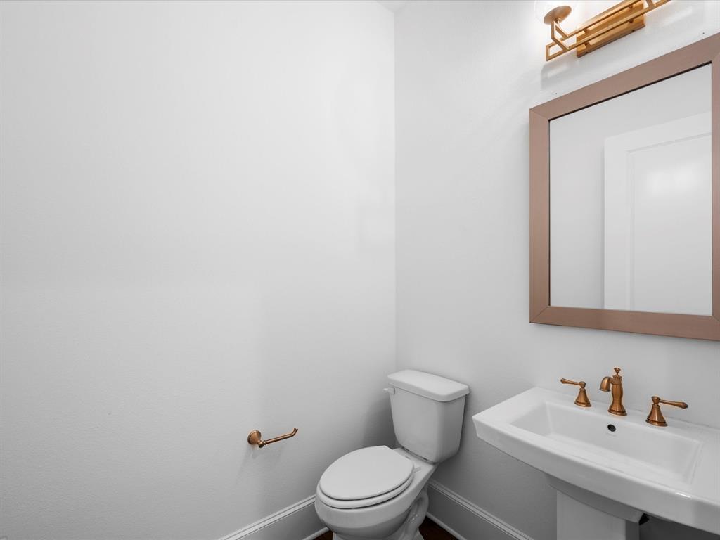 The guest powder room is located near the garage entrance and mud room for ideal privacy and features brushed brass fixtures and lighting. Waiting for your custom wall coverings to be added to make it a personalized fun space!
