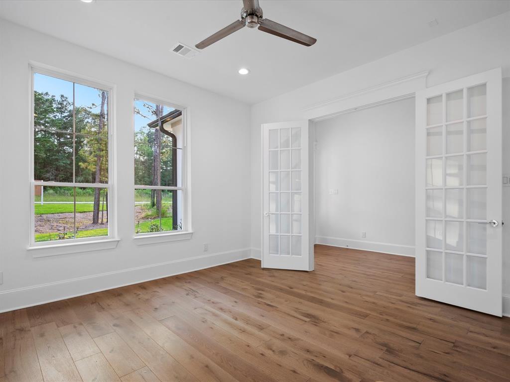 The rich and warm tones of the hardwood floor create an inviting atmosphere which, combined with the elegant French doors, give the room a sophisticated and classic feel.