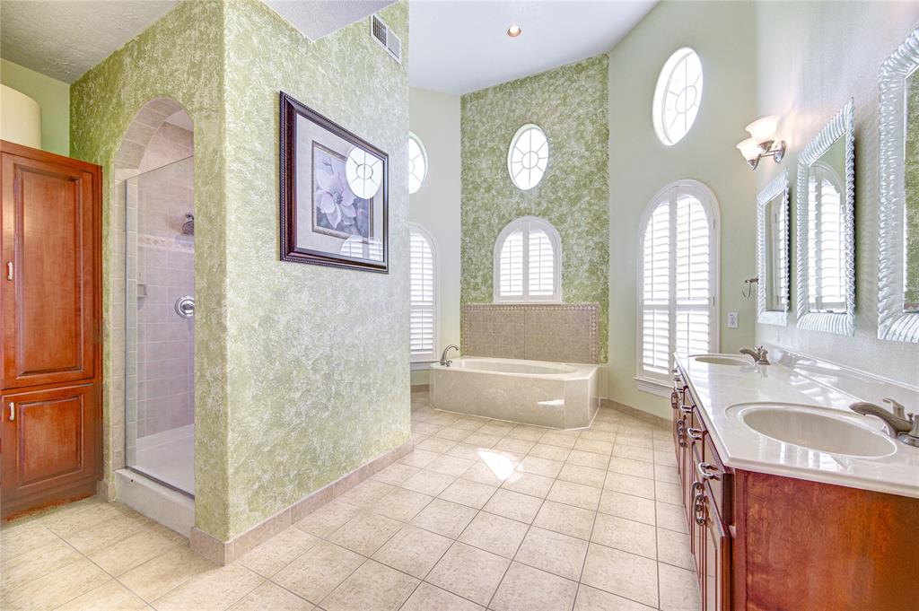 Primary Bathroom offers spa-like tub and separate stand-up shower with dual showerheads.
