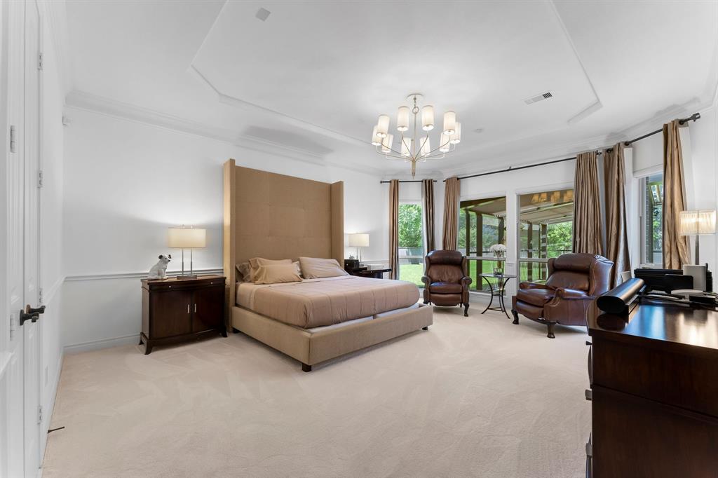 Enter the Primary room and enjoy the sitting area in front of the bay windows. The Primary suite has views of the covered outdoor living space and the screened in covered dog run.