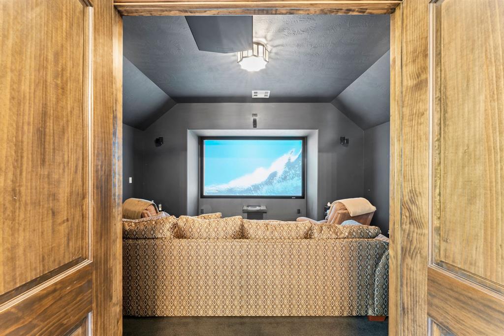 Behind double doors is the media room featuring a new Sony 4k projector and a 120" custom Stewart Film Screen.