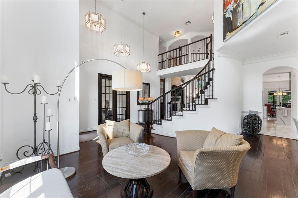 A view of the designer upgraded light fixtures, French doors leading to the office, and the cat walk upstairs from the formal living room.