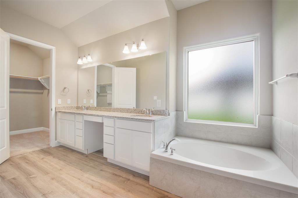 Double vanity and garden style tub with wonderful/large privacy window accent the primary bath.  Walk-in closet.