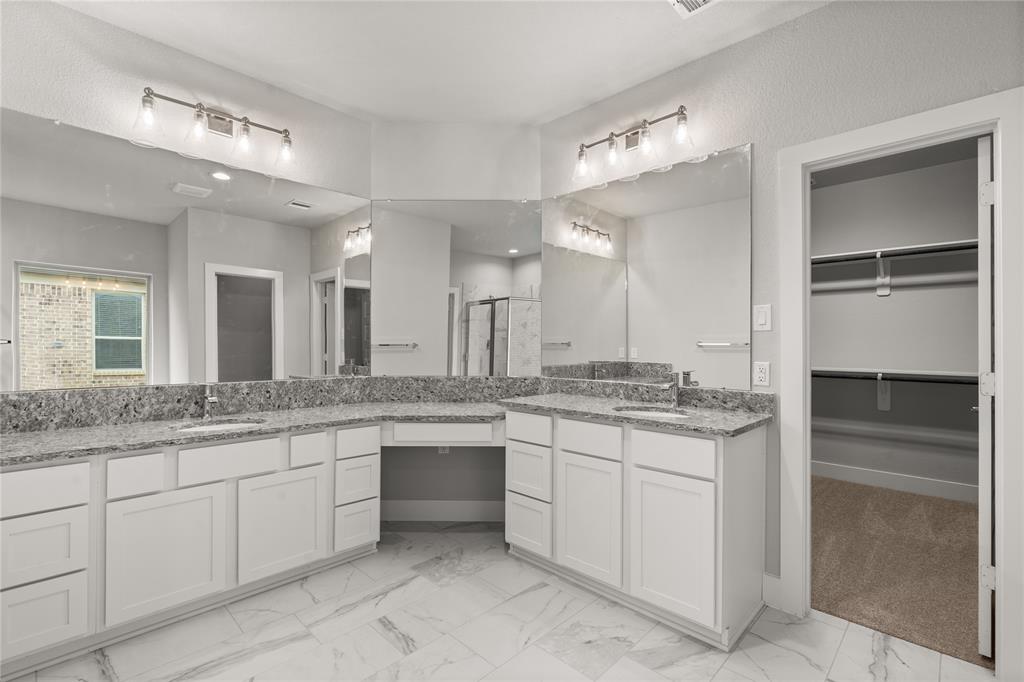 This primary bathroom is definitely move-in ready! Featuring white stained cabinets with light countertops, spacious walk-in closet with shelving, high ceilings, custom paint, sleek and dark modern finishes.