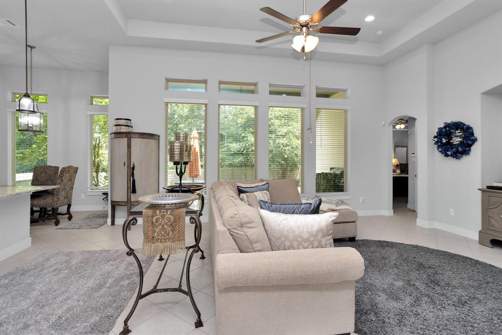 Living Room with High Vaulted Ceilings and Wall of Windows overlooking the Backyard and Greenbelt.