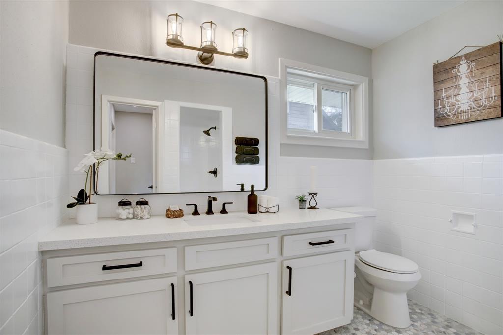 Primary bathroom features barn door entry and a wall of custom cabinets.
