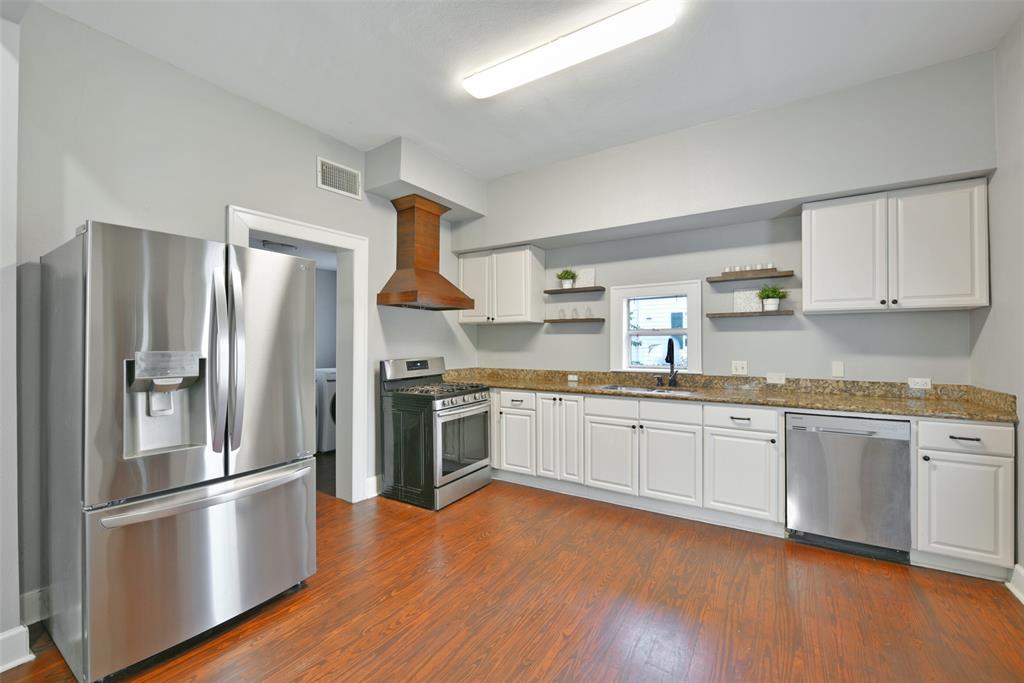 An impressively sized eat-in kitchen is tucked on the opposite side of the staircase. The chef of the house is certain to appreciate the all stainless appliances that include a 5 burner gas cooktop and oven, a dishwasher, and a dual basin sink with a gooseneck faucet.