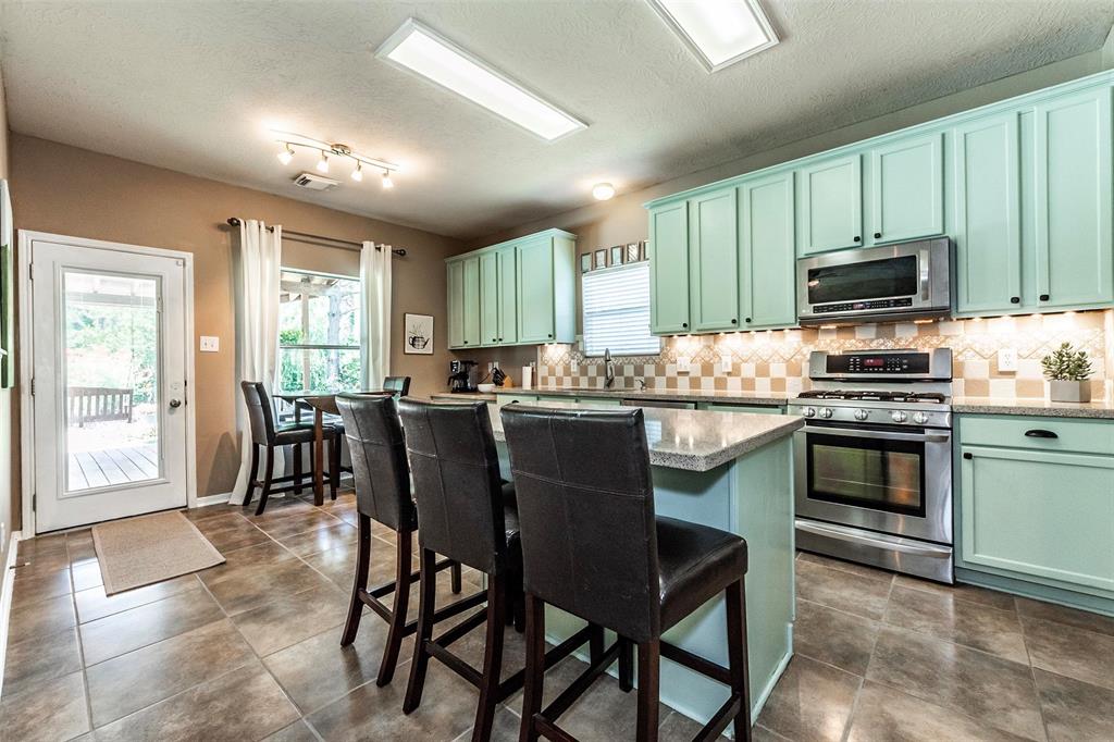 Gourmet island kitchen with custom coastal-color cabinets, ceramic tile flooring, gorgeous Quartz counter tops and LG stainless steel appliances.