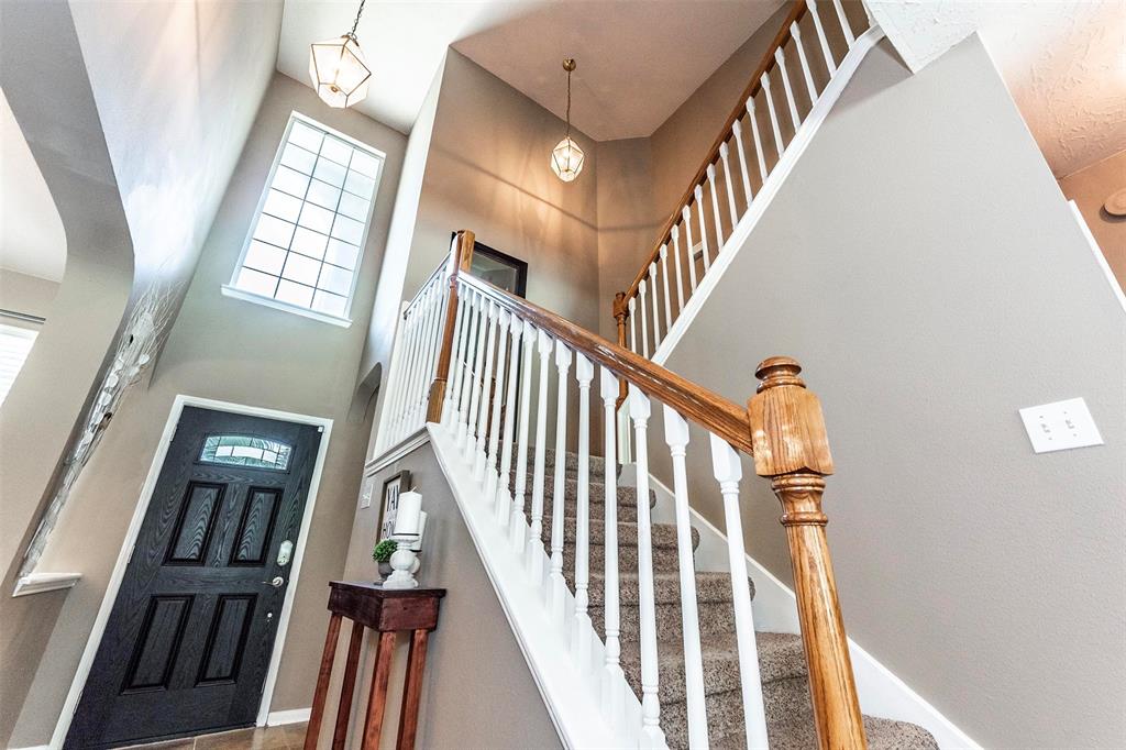 Split staircase leading to 2nd level with wood banisters railing and upgraded carpet/padding.