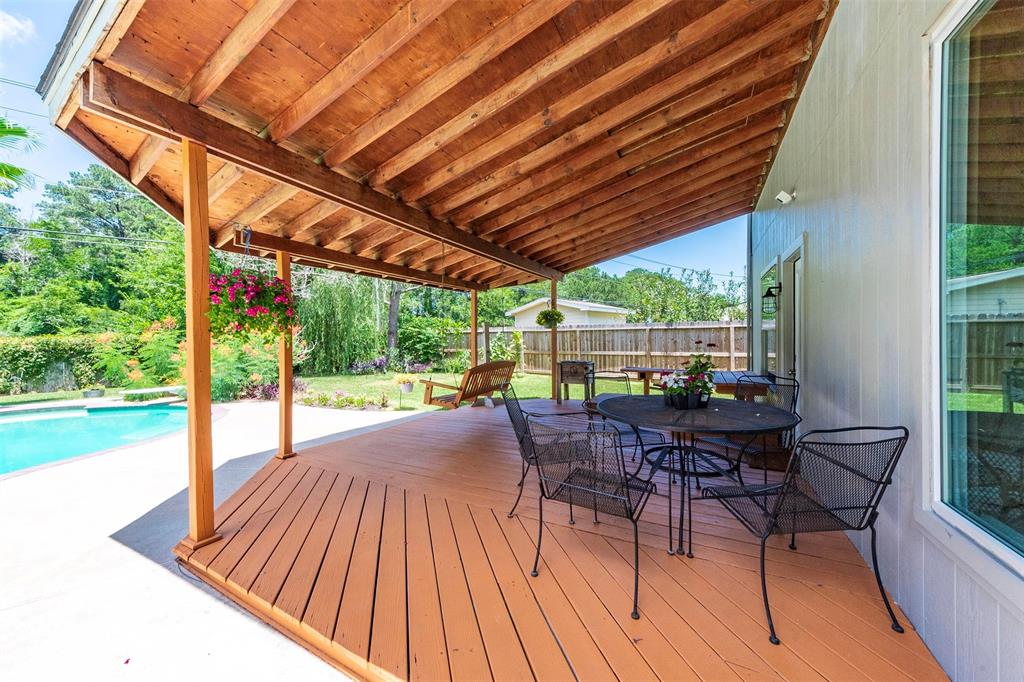 Beautiful covered backyard wood patio and deck with tons of shade.