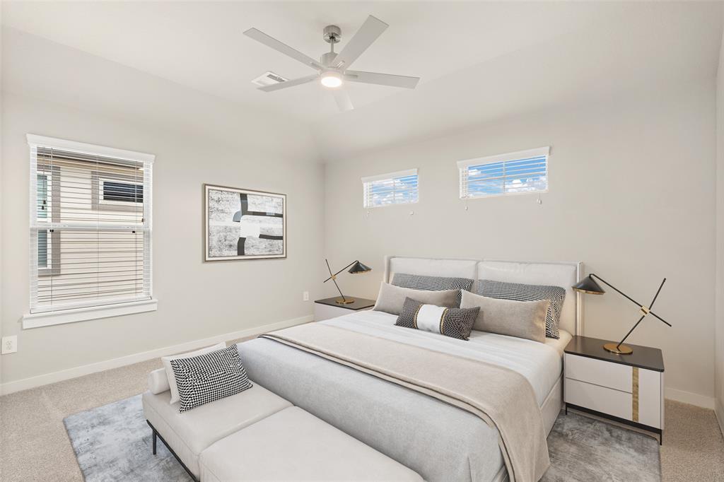Secondary bedroom features plush carpet, custom paint, ceiling fan with lighting and a large window with privacy blinds.