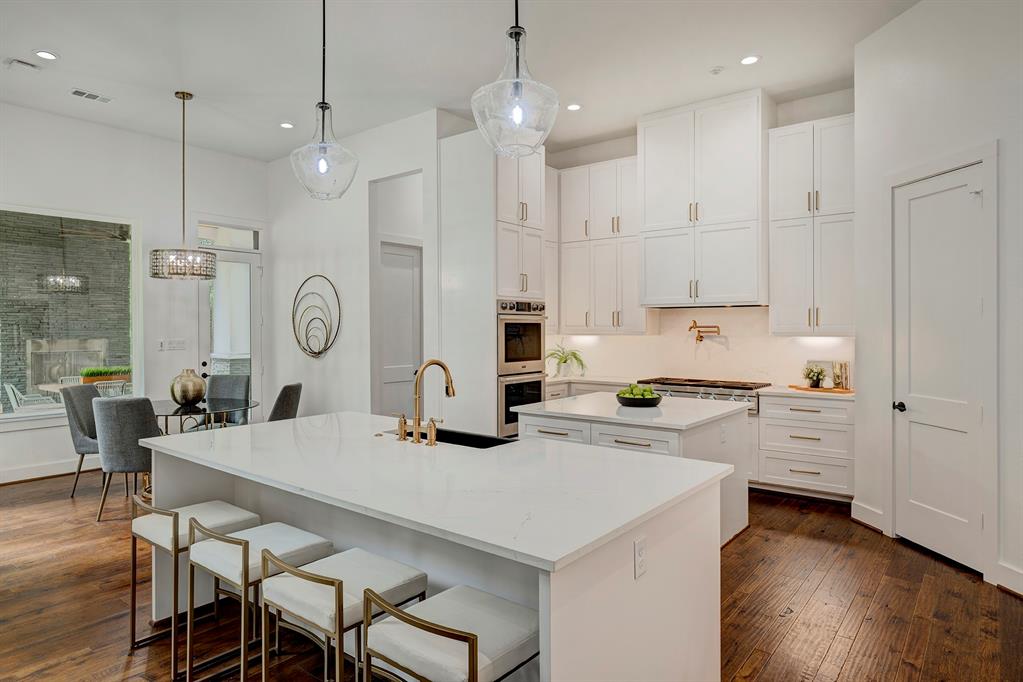 Showpiece kitchen anyone? This classic kitchen is clad in white cabinets, Silestone countertops, and marble back splash.