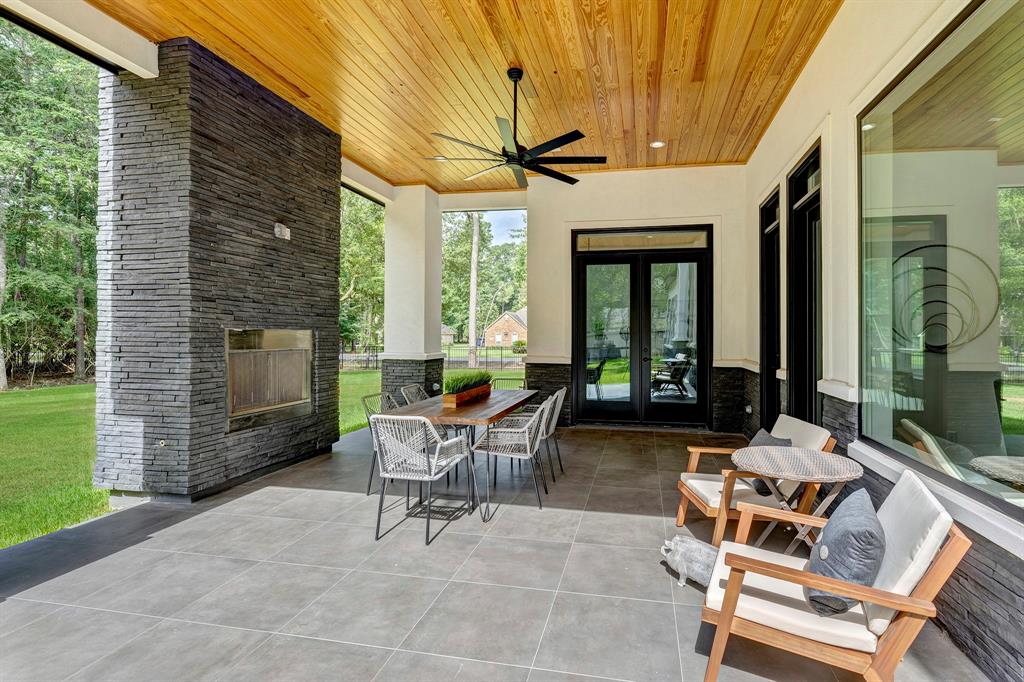 The extended covered patio provides year round outdoor living! A stacked stone wainscot is matched with the outdoor fireplace. Stained wood ceiling enlightens the space.