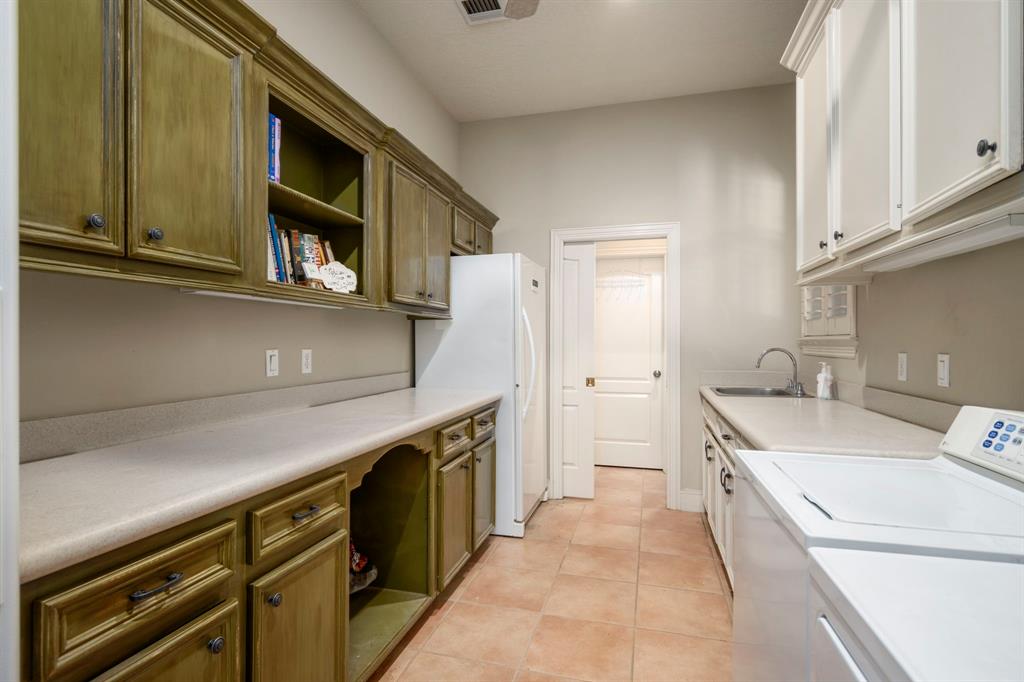 Spacious laundry room with a half bath in the back and more closet space beyond that. The laundry/half bath is right by the door that goes to the pool, so it makes it convenient to change into and out of swim wear.